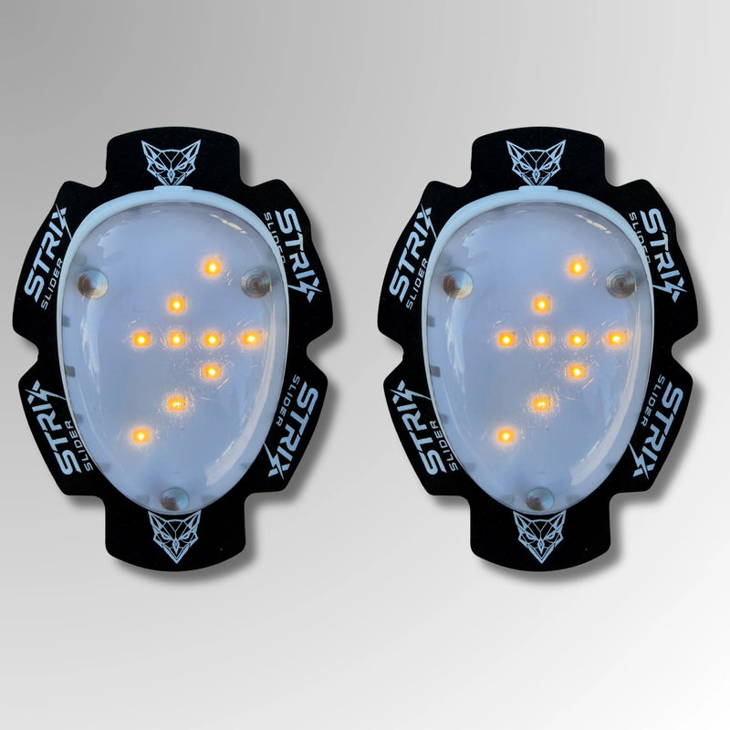Par de deslizaderas Strix® LED de rodilla con luz encendida en forma de cruz, fondo de estudio